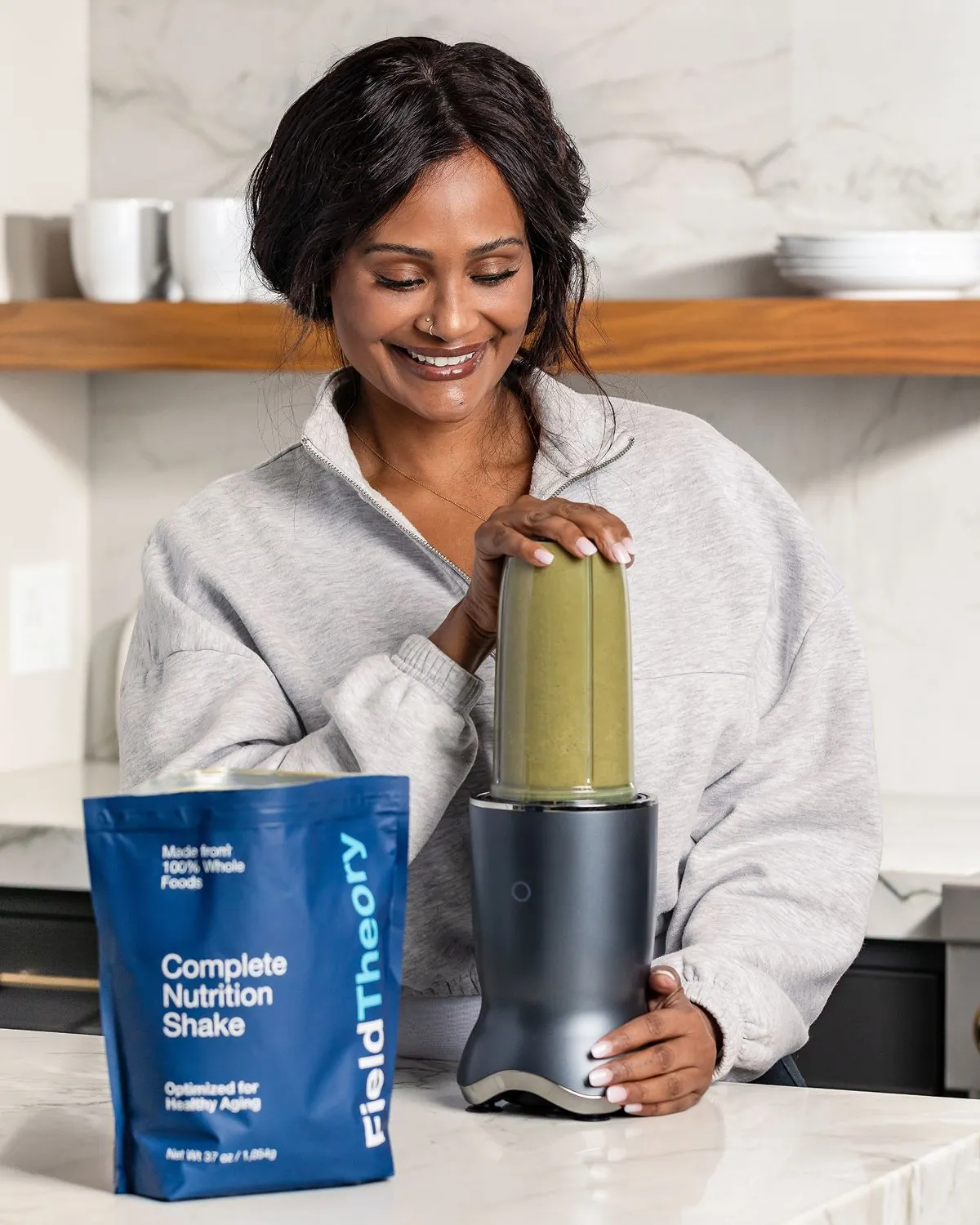 A woman blending Field Theory beside the pouch